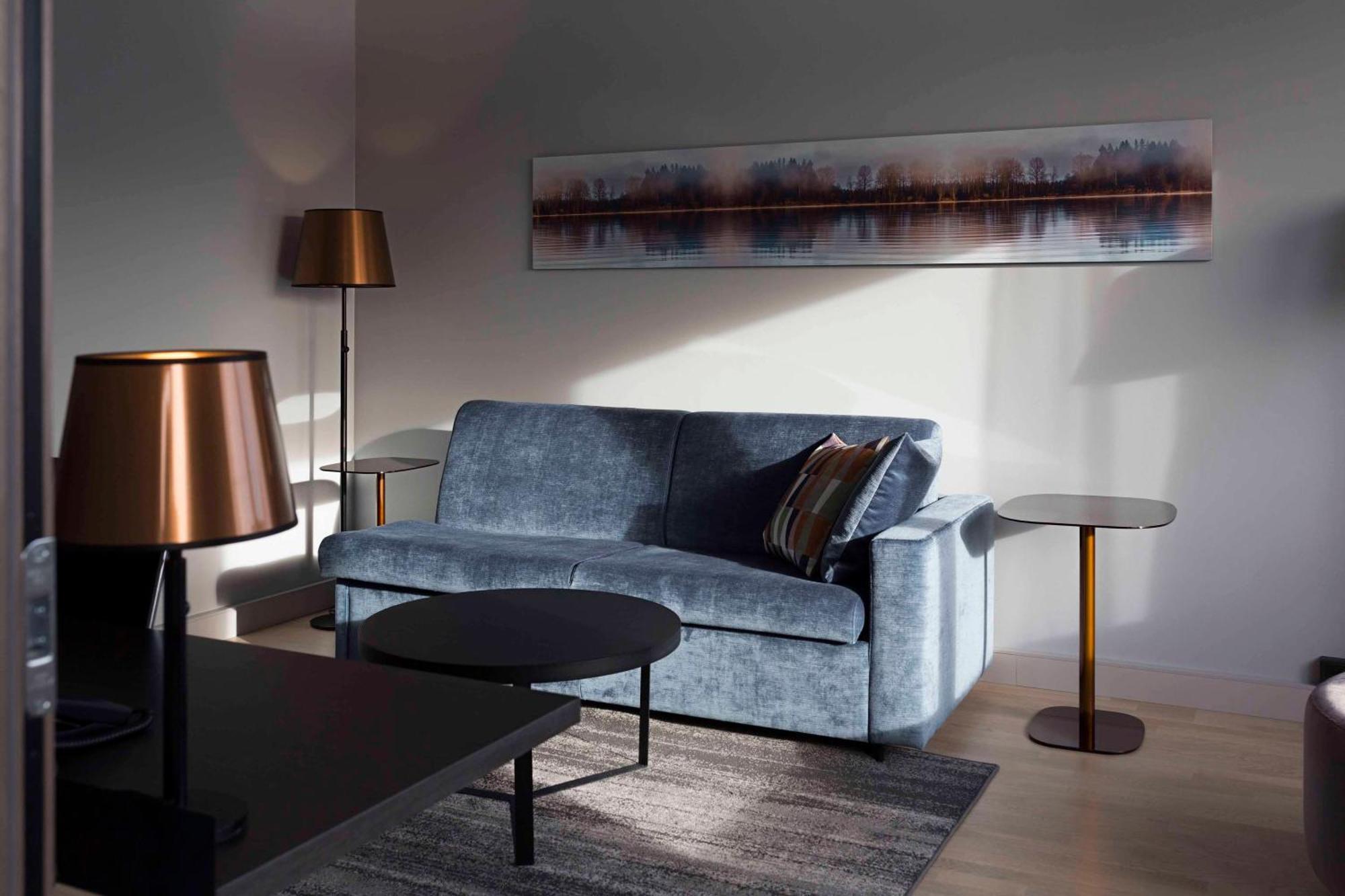 Hilton Helsinki Strand Kültér fotó A living room with a blue sofa